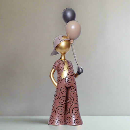 Decorative figurine of a person holding balloons against a white background