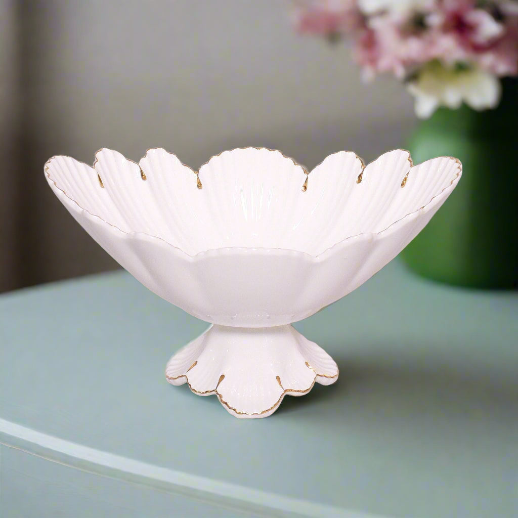 White decorative bowl with scalloped edge on a light green surface