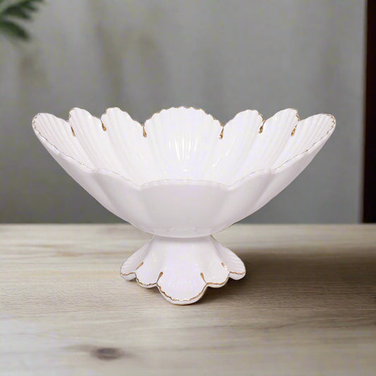 White decorative bowl with scalloped edge and gold trim on a light gray background