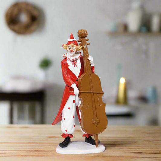 Figurine of a clown playing a cello on a wooden surface with a blurred background