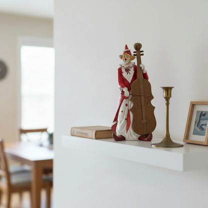 Decorative figure of a clown playing a cello on a shelf in a room with a dining table and chairs.