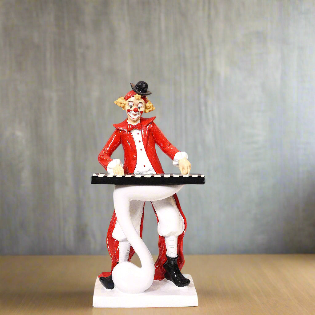 Statue of a clown playing a keyboard on a plain background
