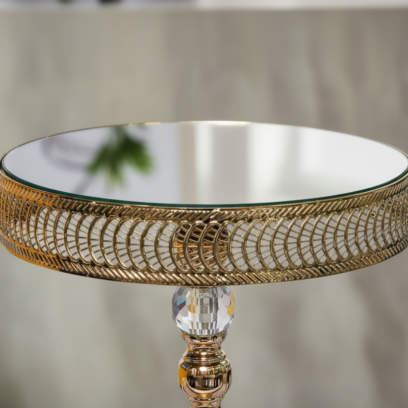 Decorative round table with gold metal frame and crystal base on a blurred background