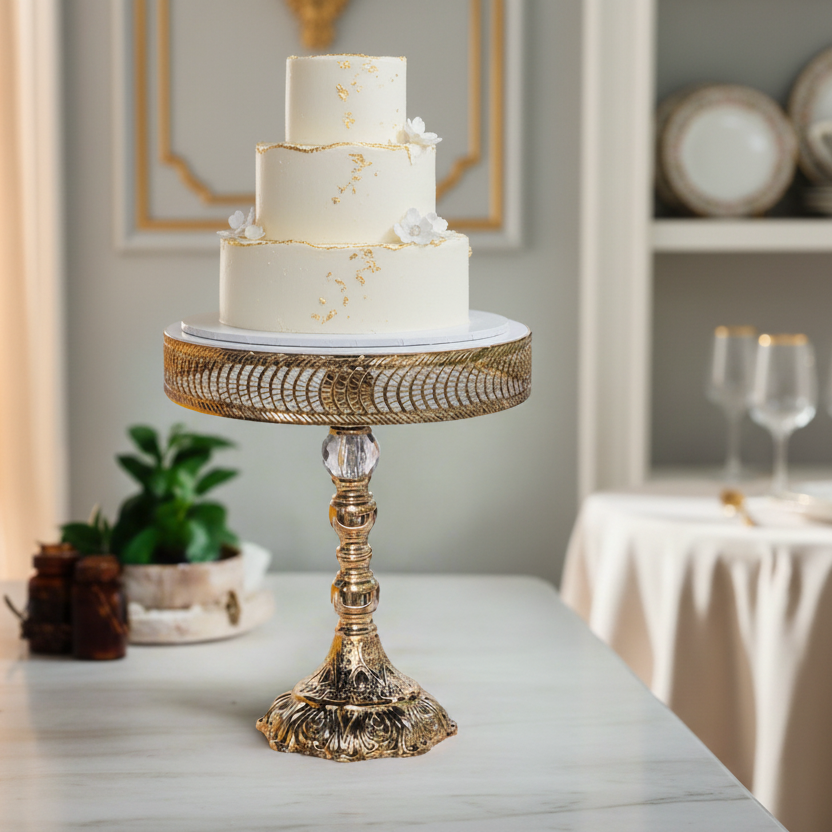 Three-tiered wedding cake on a decorative stand in a elegant room setting.