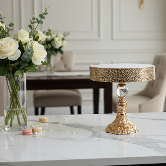 Decorative table lamp on a marble surface with flowers and plates in the background
