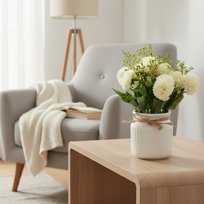 White flowers in a small white vase with twine on a light gray background