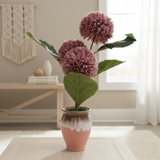 Potted plant with purple flowers in a room with a table and decorative items.