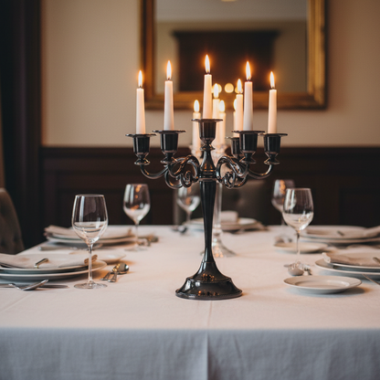 Candelabra with lit candles on a dining table set for dinner.