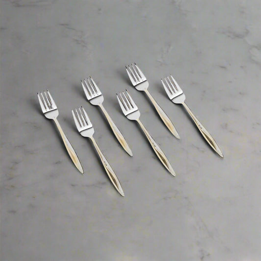 Set of six silver forks with wooden handles on a white background