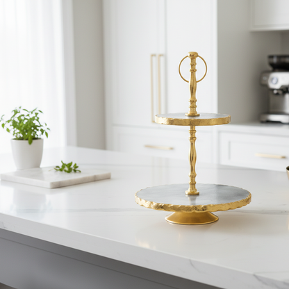 Gold cake stand on a white countertop with a blurred kitchen background