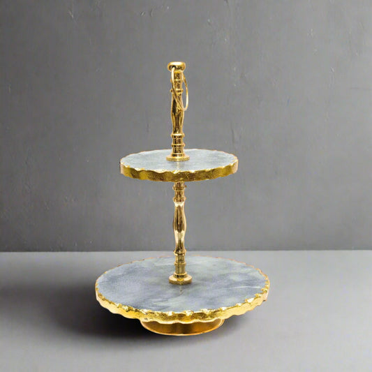 Two-tiered serving tray with gold accents on a white background
