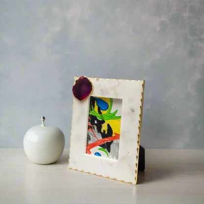 Marble picture frame with a colorful painting inside on a white background
