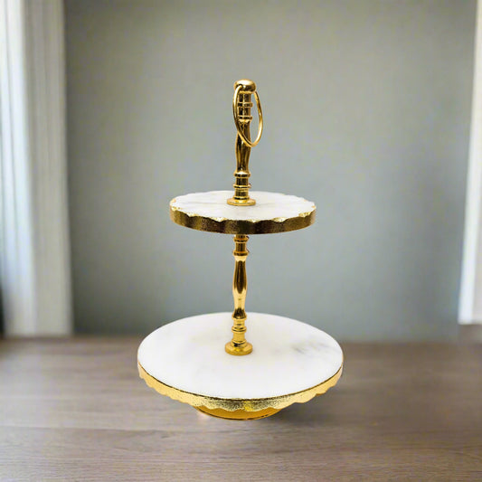 Two-tiered serving tray with gold trim on a white background