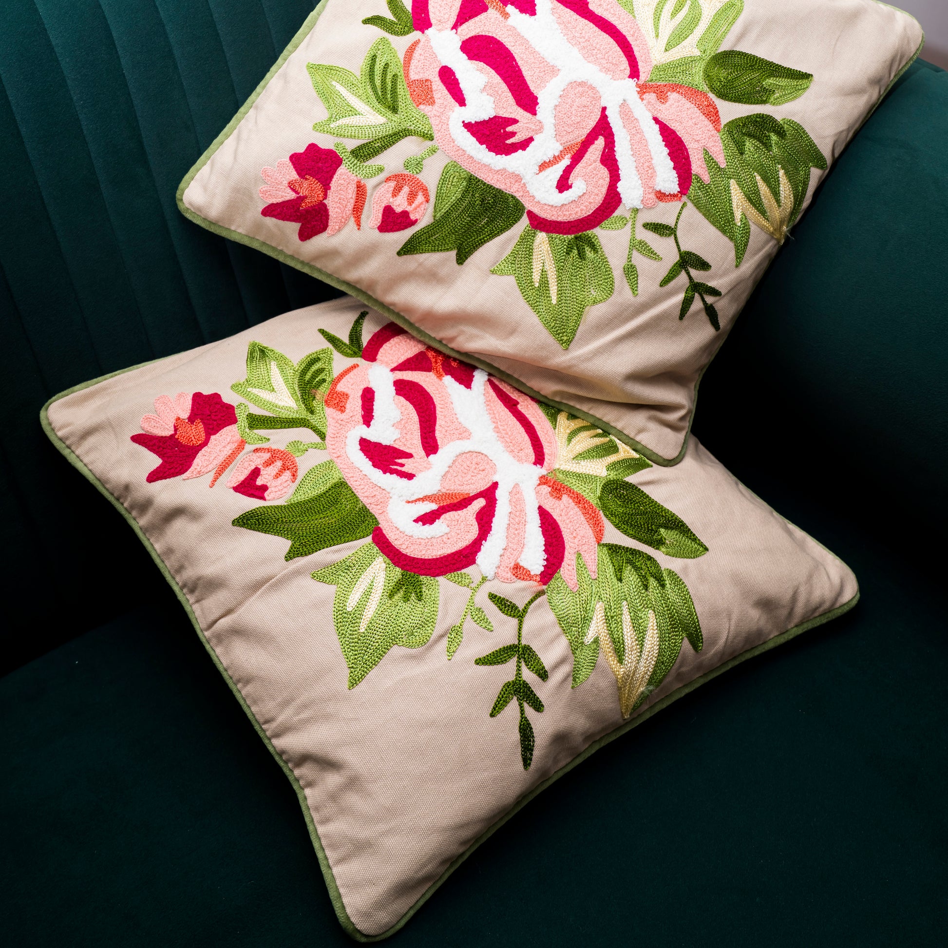 Two floral embroidered pillows on a dark surface