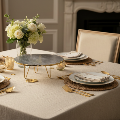 Elegant table setting with floral arrangement, candles, and gold cutlery in a formal dining room.
