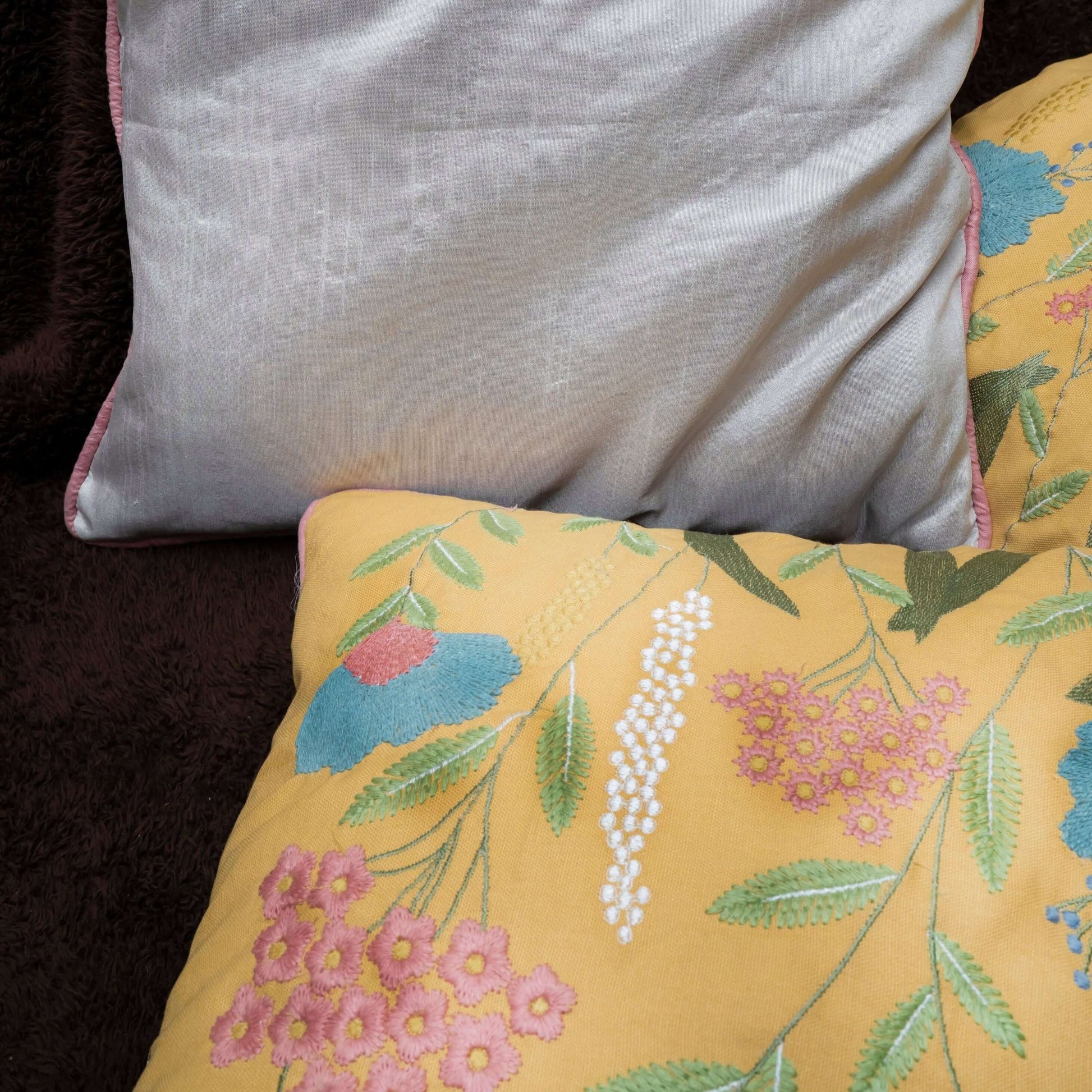 Gray pillow with pink trim on a dark background