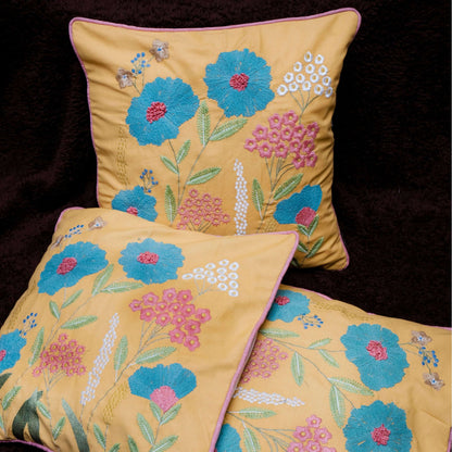 Three embroidered pillows with floral patterns on a dark background