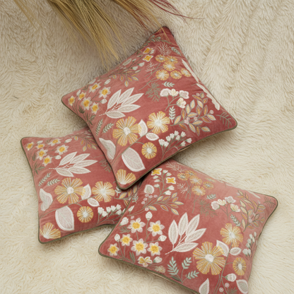 Three floral-patterned cushions on a textured surface