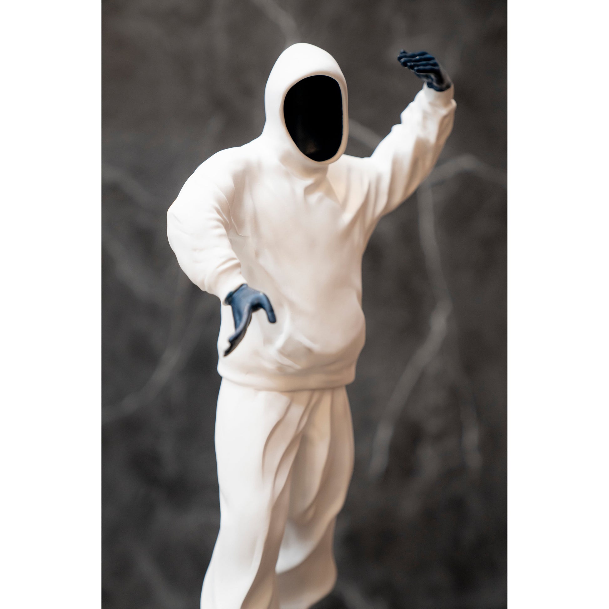 White hooded outfit with blue gloves on a dark background