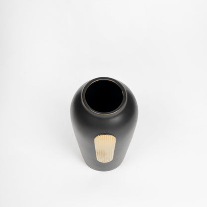 Black ceramic vase with a textured base on a white background