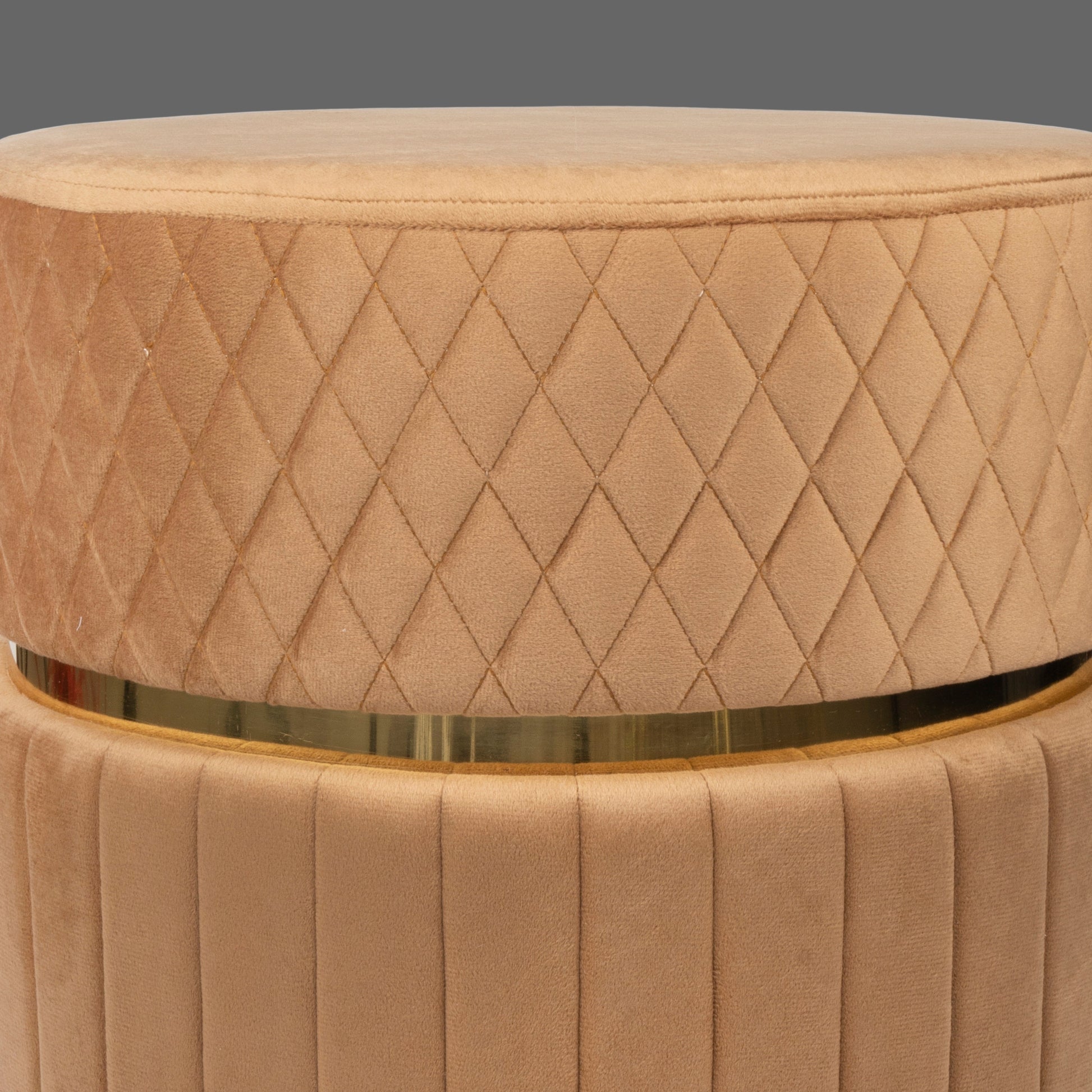 Beige quilted ottoman with a gold band on a white background