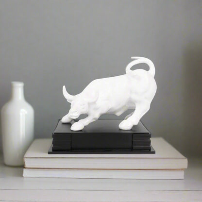 White bull sculpture on a black base against a white background