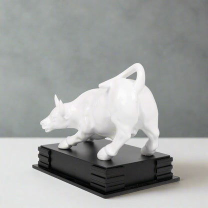 White dog sculpture on a black base against a light gray background