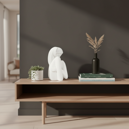 Wooden shelf with decorative items including a white sculpture, black vase, and books against a dark wall.