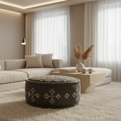 Modern living room with a beige sectional sofa, patterned ottoman, and decorative items.