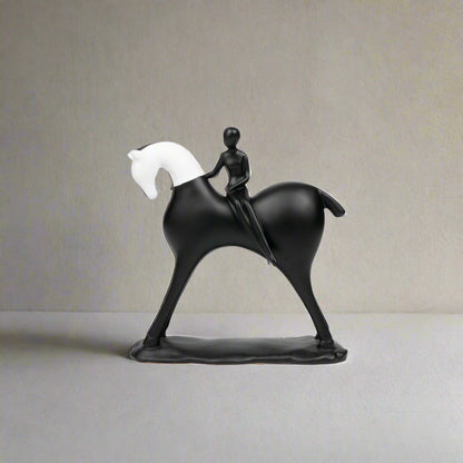 Black sculpture of a person riding a horse on a white background