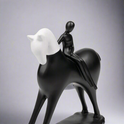 Black and white sculpture of a horse with a rider on a white background