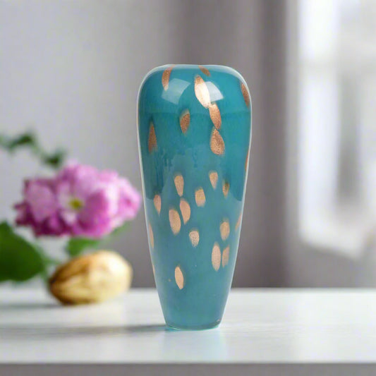 Blue ceramic vase with gold speckles on a white background
