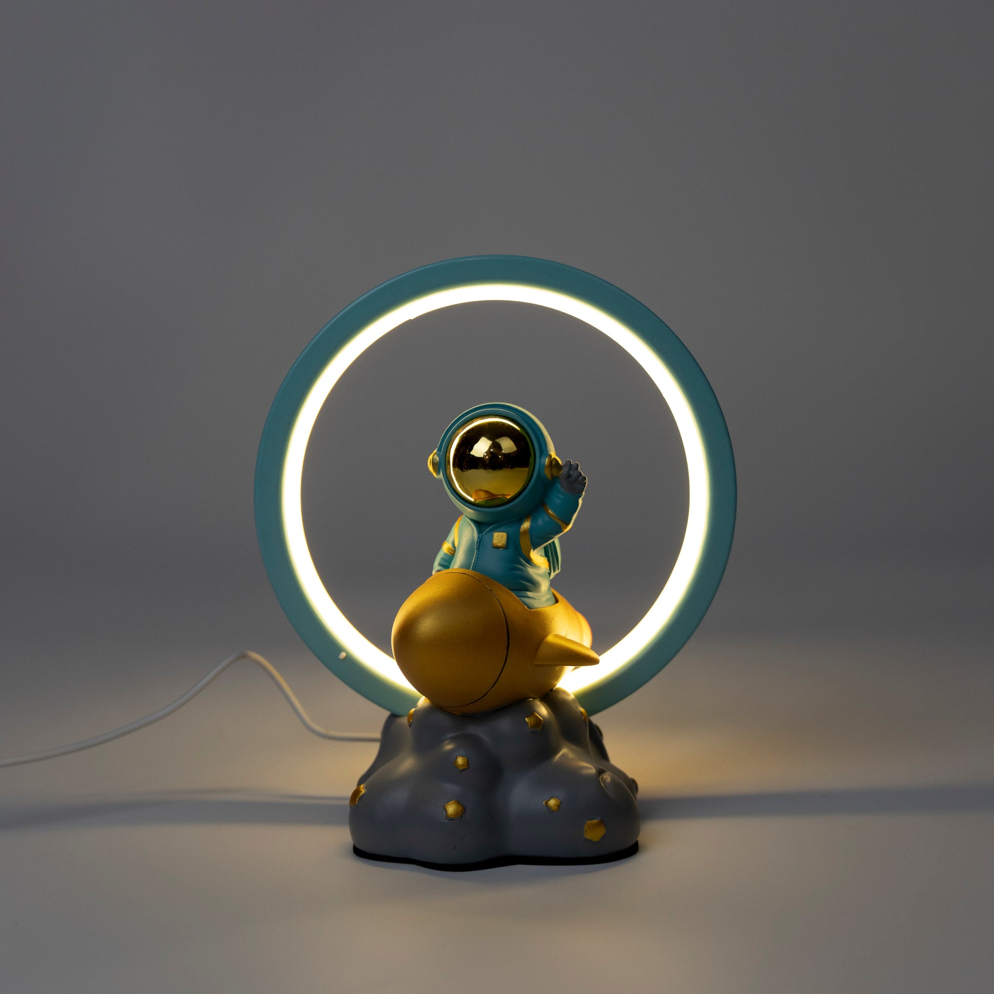 Decorative lamp with an astronaut figure on a cloud and a neon ring light.