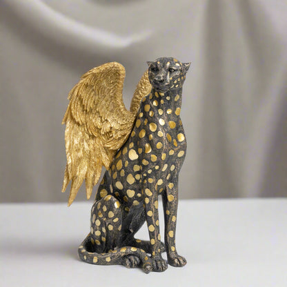 Statue of a winged creature with gold accents on a white background