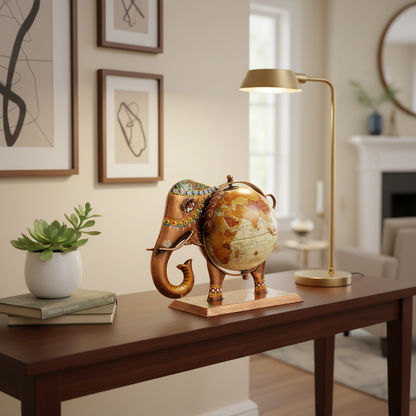 Majestic Hand-Painted Elephant Globe displayed on a wooden table with decorative plants and lamp.