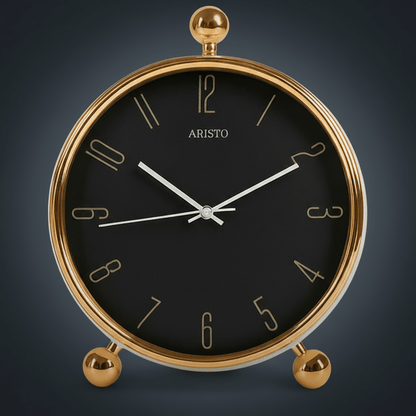 Gold-framed clock with black face on a white background