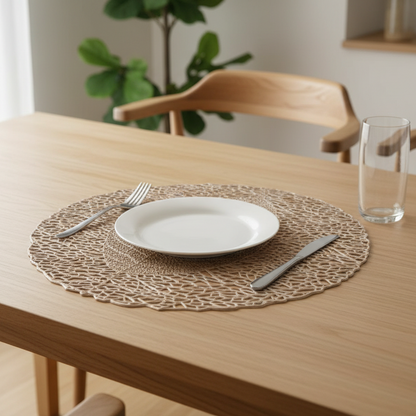 Dining table setting with a white plate, fork, knife, and glass on a woven placemat.