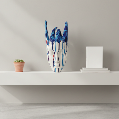Ceramic vase shaped like a face with blue and white patterns on a wooden surface.