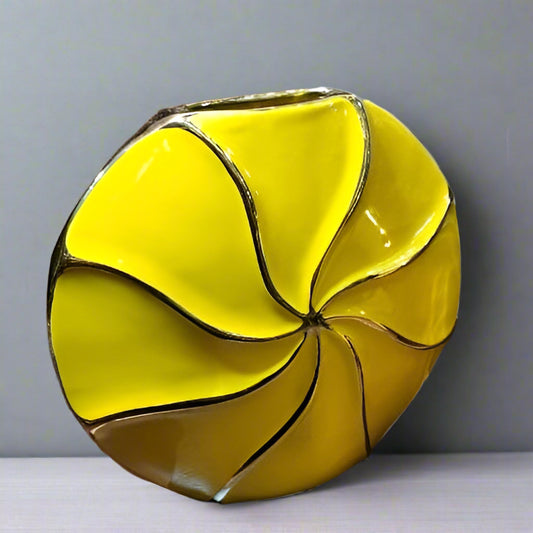 Yellow glass vase with a unique design on a gray background