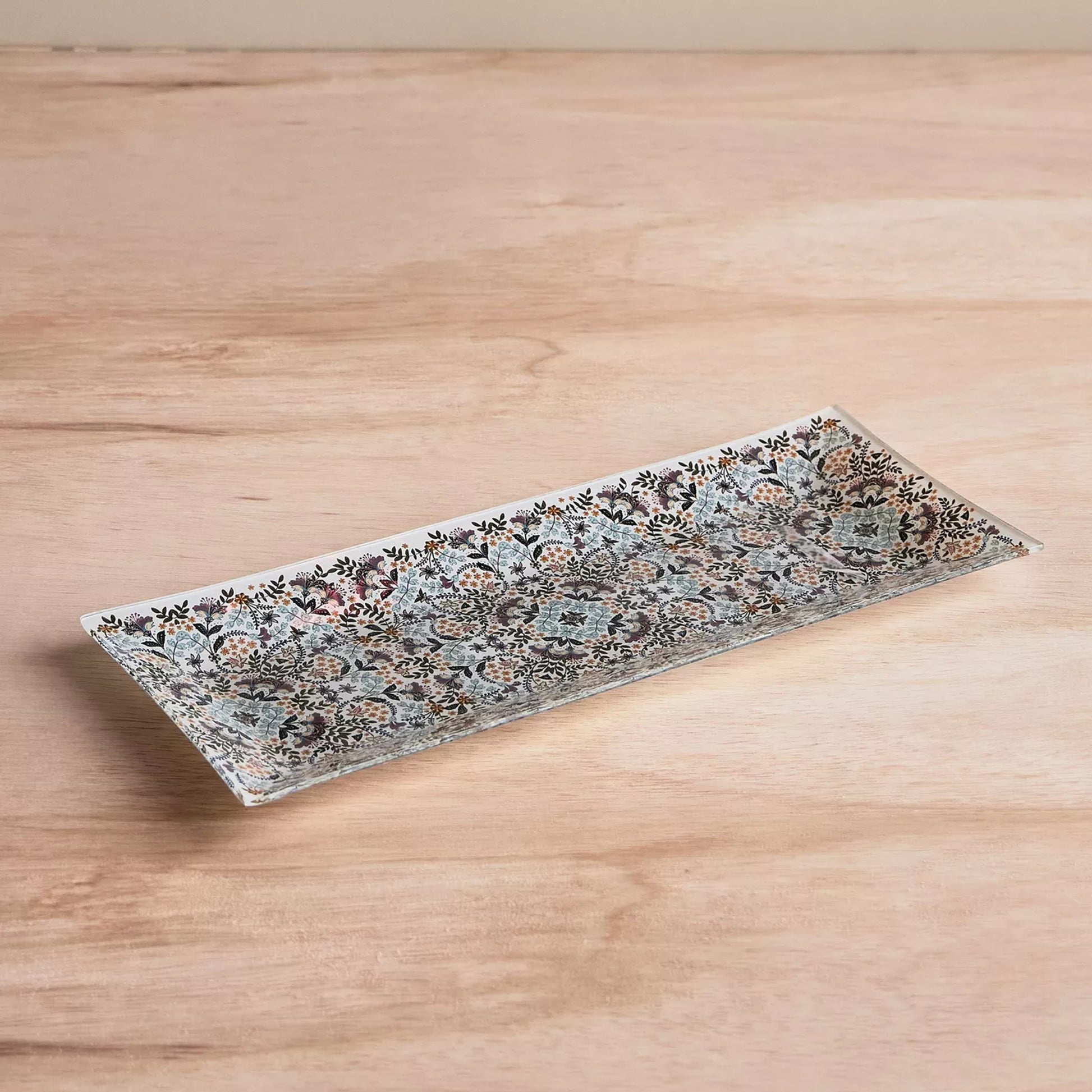 Decorative rectangular plate with floral pattern on a wooden surface