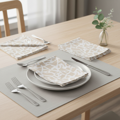 Dining table setting with patterned napkins, plates, and cutlery on a wooden table.