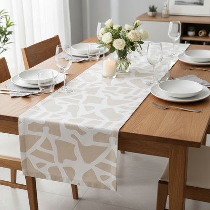 Dining table set with a patterned table runner, plates, glasses, and flowers.