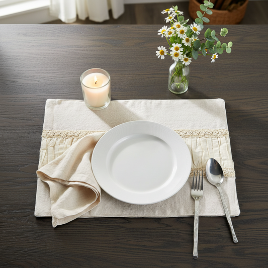 Dining table setting with a white plate, napkin, cutlery, candle, and flowers on a wooden surface.