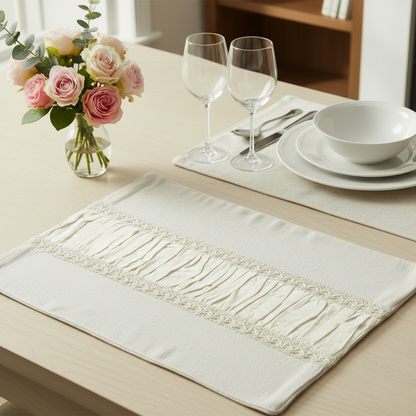 Dining table setting with a decorative placemat, flowers, and cutlery.