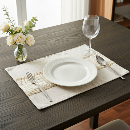 Dining table setting with a white plate, fork, spoon, and wine glass on a placemat.