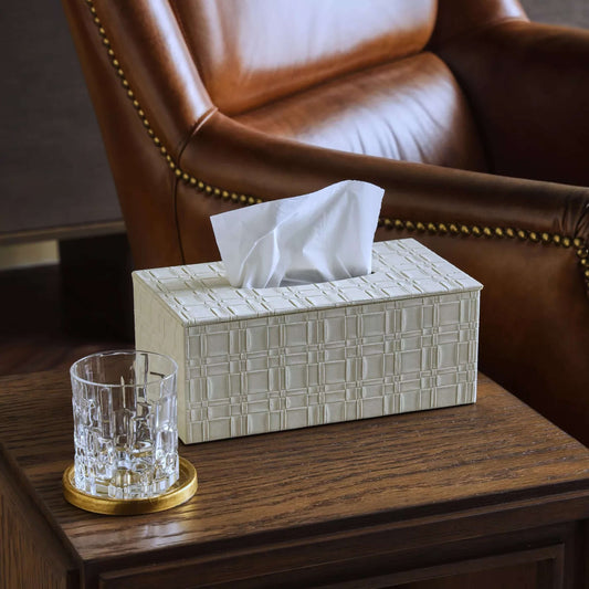 Tissue box with a glass on a wooden table in front of a brown leather chair