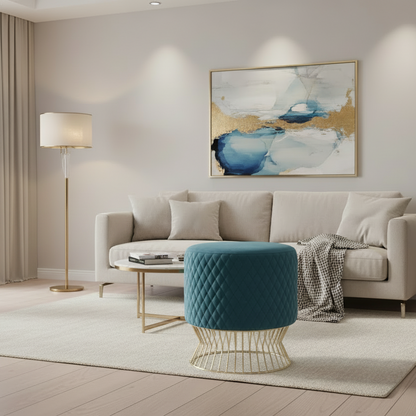 Modern living room with a beige sofa, blue ottoman, and abstract art on the wall.