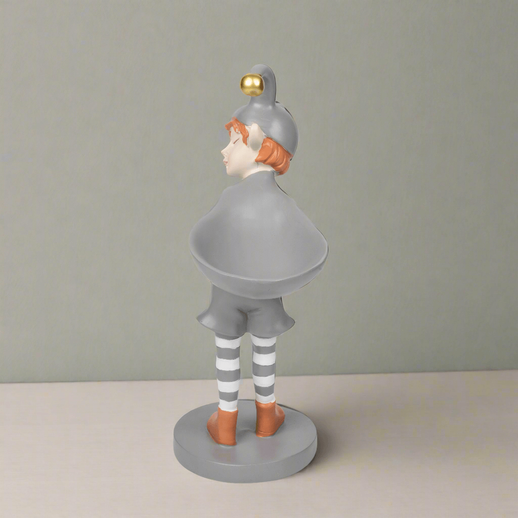 Statue of a person in a gray outfit with a gold helmet on a plain background