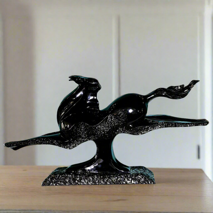 Black horse sculpture on a wooden surface with a neutral background