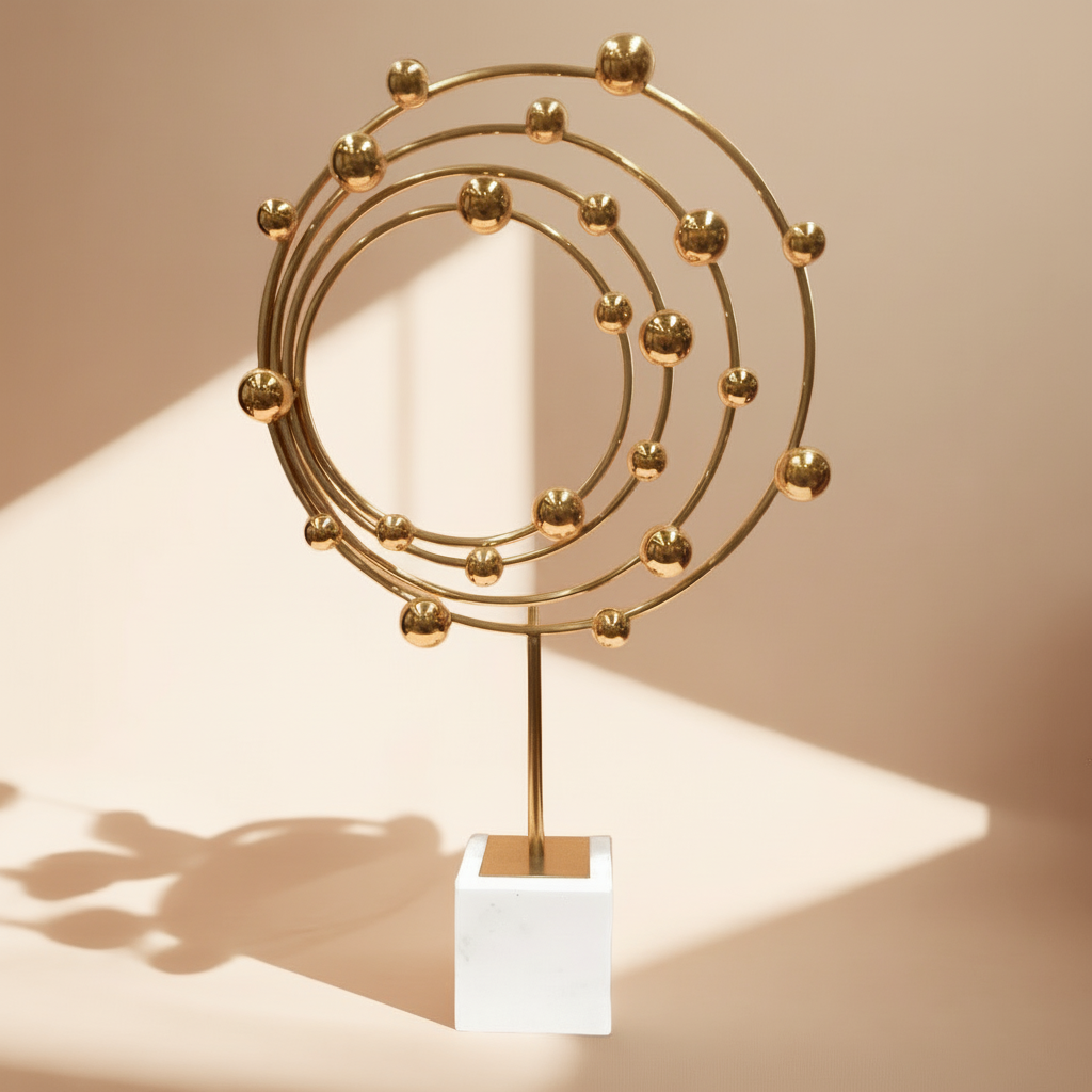 Gold circular sculpture on a white pedestal against a gray background
